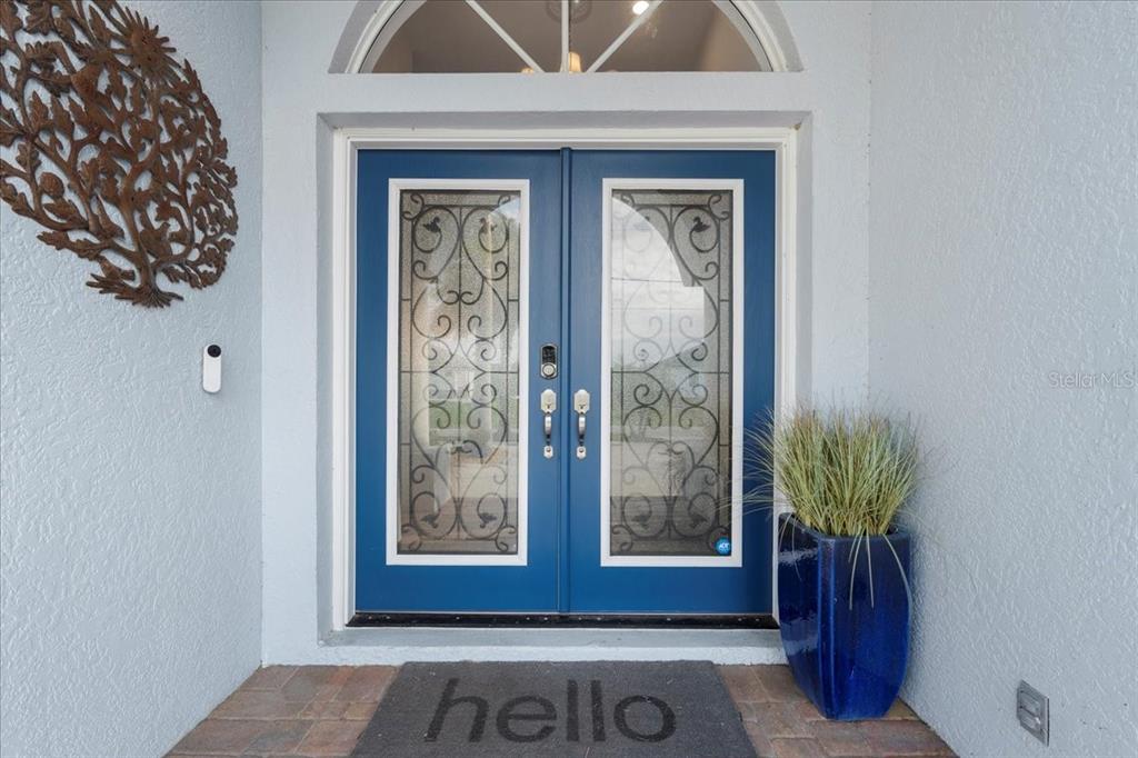 A blue double front door with decorative glass inserts sits under an arched transom window — 1091 ROTONDA CIRCLE, ROTONDA WEST, FL