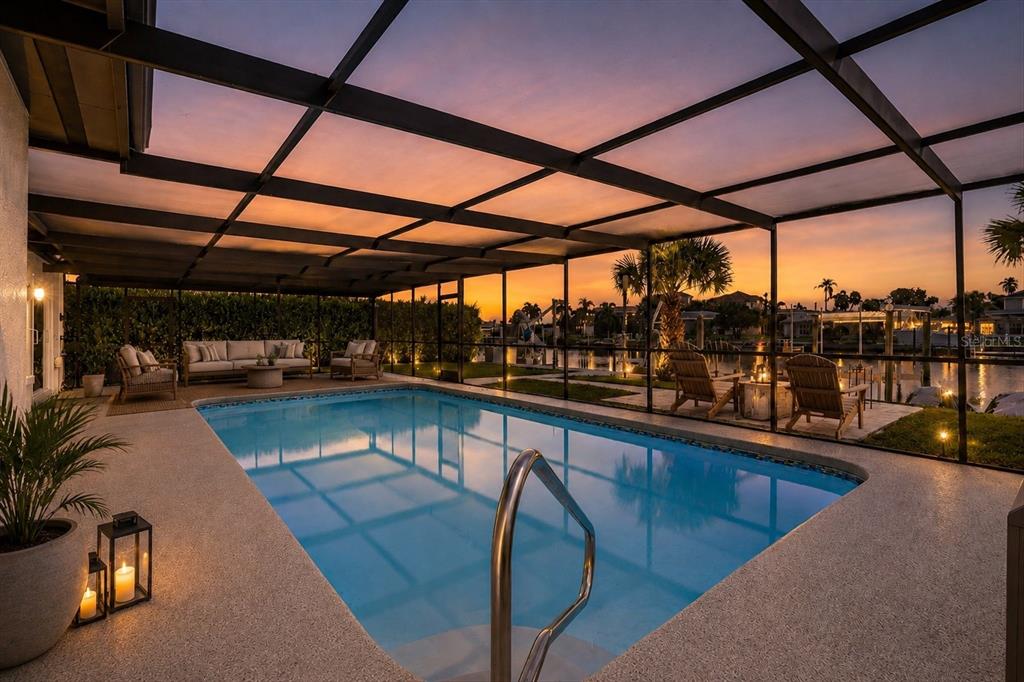 An aerial view shows a waterfront house with a flat roof and a large driveway — 5524 LEEWARD LANE, NEW PORT RICHEY, FL