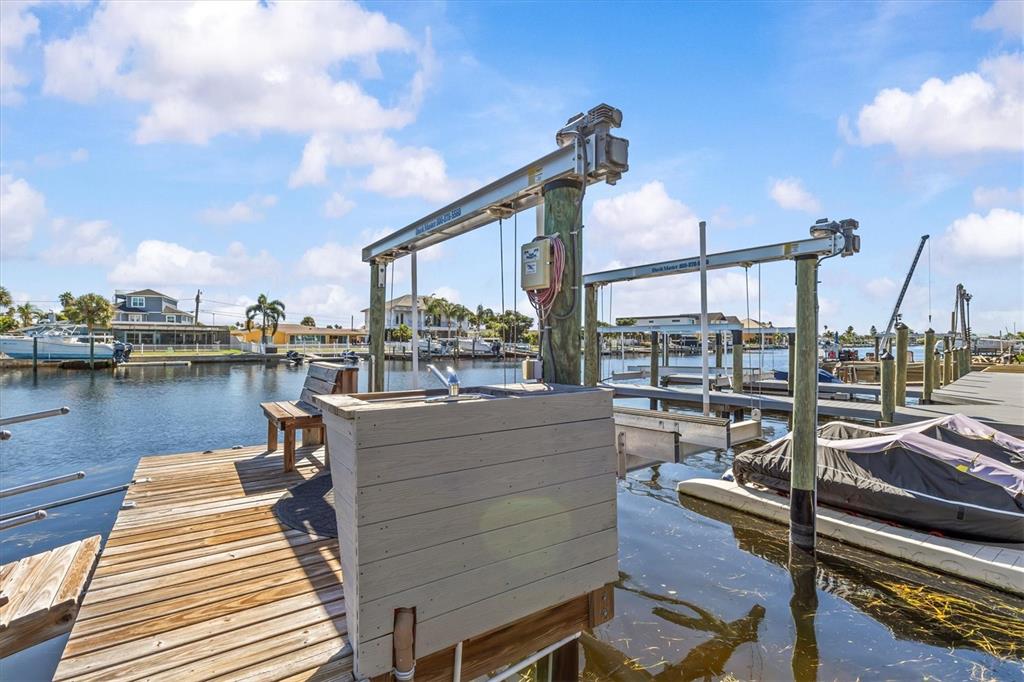 A single-story house with a dark mansard roof and illuminated driveway at sunset — 5524 LEEWARD LANE, NEW PORT RICHEY, FL