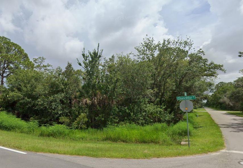 A vacant, wooded corner lot sits at the intersection of two paved roads — 10 DARROW STREET, PORT CHARLOTTE, FL