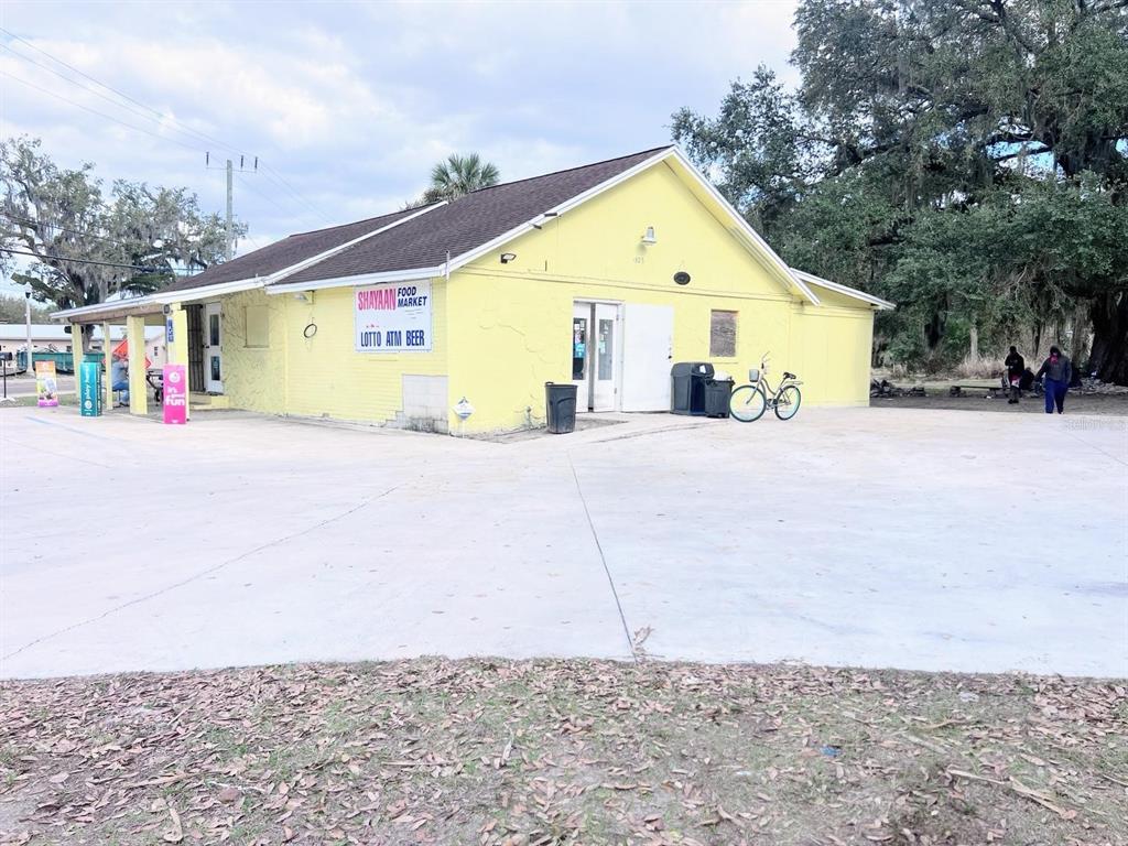 A yellow, single-story commercial building with a concrete parking lot and a bicycle parked outside — 1805 HISTORIC GOLDSBORO BOULEVARD, SANFORD, FL