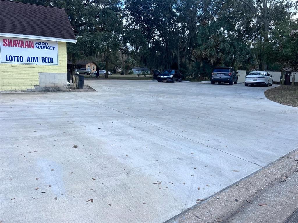A paved parking lot sits in front of a yellow building labeled Shayaan Food Market — 1805 HISTORIC GOLDSBORO BOULEVARD, SANFORD, FL