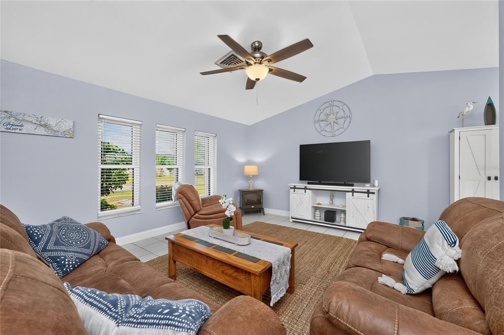 A living room features brown leather furniture, a wooden coffee table, and a television console — 255 MARK TWAIN LANE, ROTONDA WEST, FL