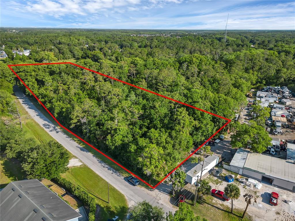 An aerial view shows a wooded, rectangular plot of land outlined in red along a road — 502 N 5TH STREET N, ORLANDO, FL