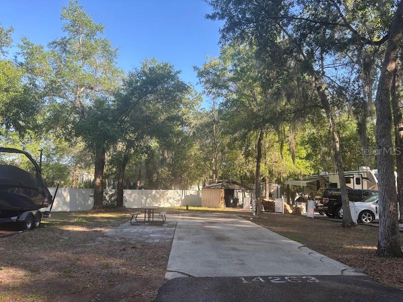 An outdoor paved lot features a picnic table, a small shed, and a parked boat — 14263 NE 252ND COURT ROAD UNIT 114, SALT SPRINGS, FL