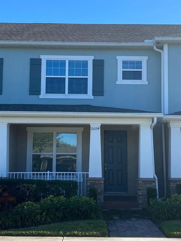 A row of multi-story townhomes with gray siding, white trim, and covered front porches — 15334 MURCOTT BLOSSOM BOULEVARD, WINTER GARDEN, FL