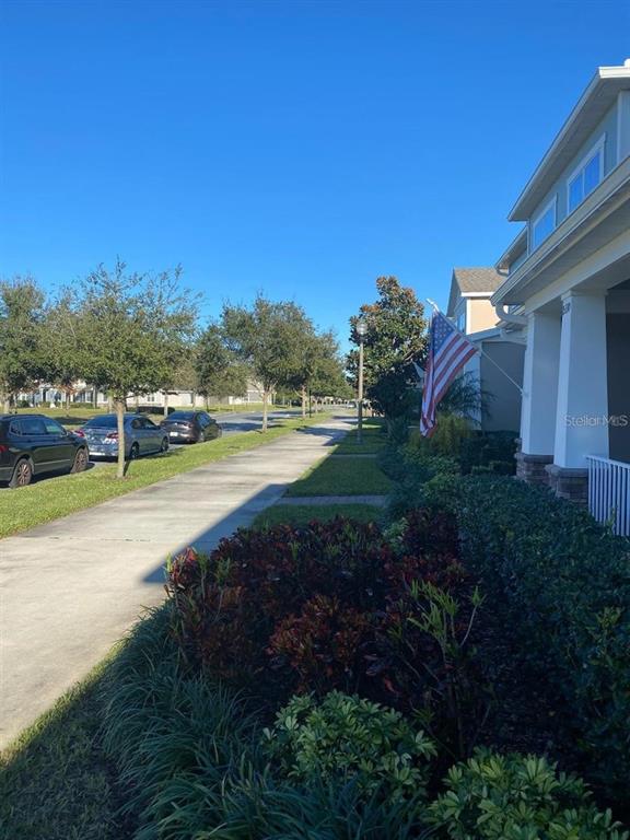A multi-unit residential building exterior with a covered porch, stone accents, and manicured landscaping — 15334 MURCOTT BLOSSOM BOULEVARD, WINTER GARDEN, FL