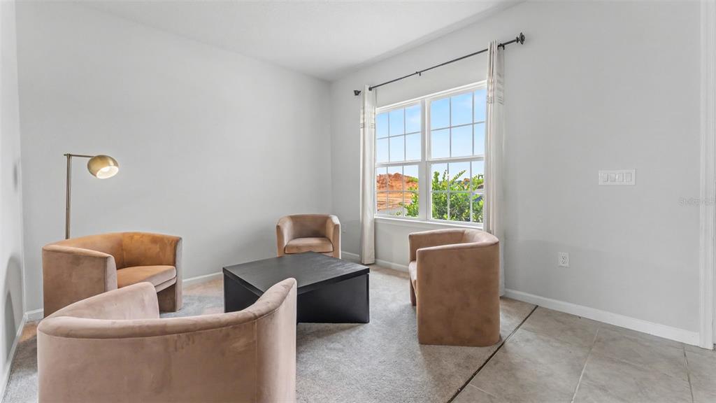 A living room features four tan armchairs, a black coffee table, and a large window — 2075 AIREDALE WAY, LAKE ALFRED, FL