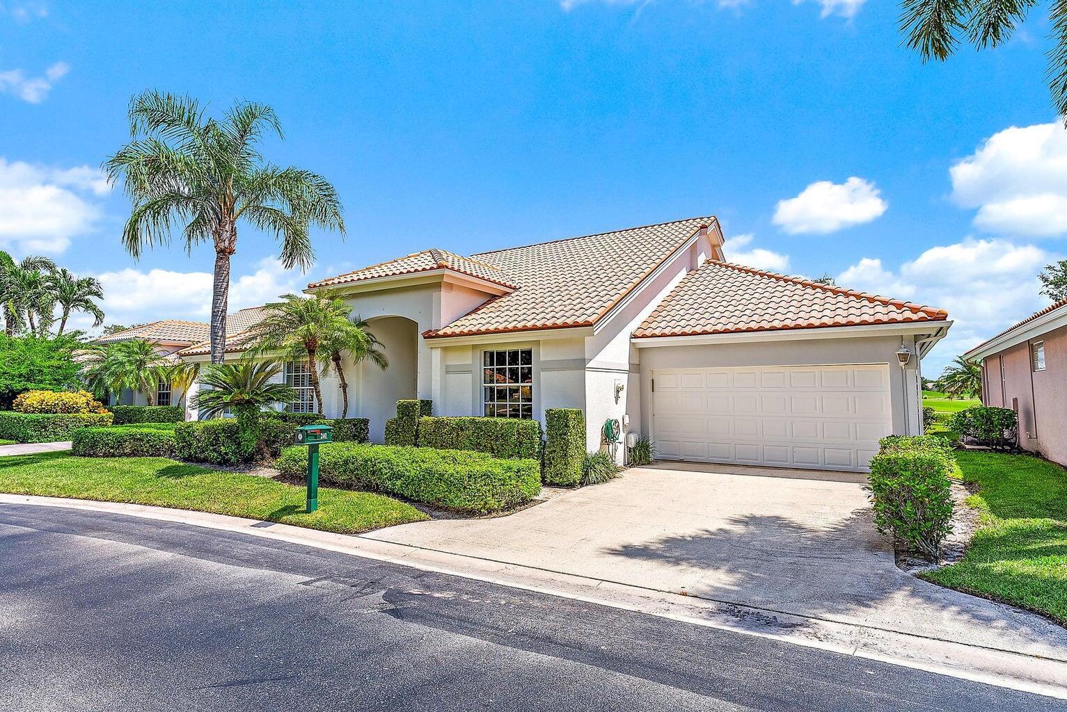 A single-story suburban house with a tiled roof, white stucco walls, and a two-car garage — 240 Eagleton Estate Boulevard, Palm Beach Gardens FL 33418, PALM BEACH GARDENS, FL