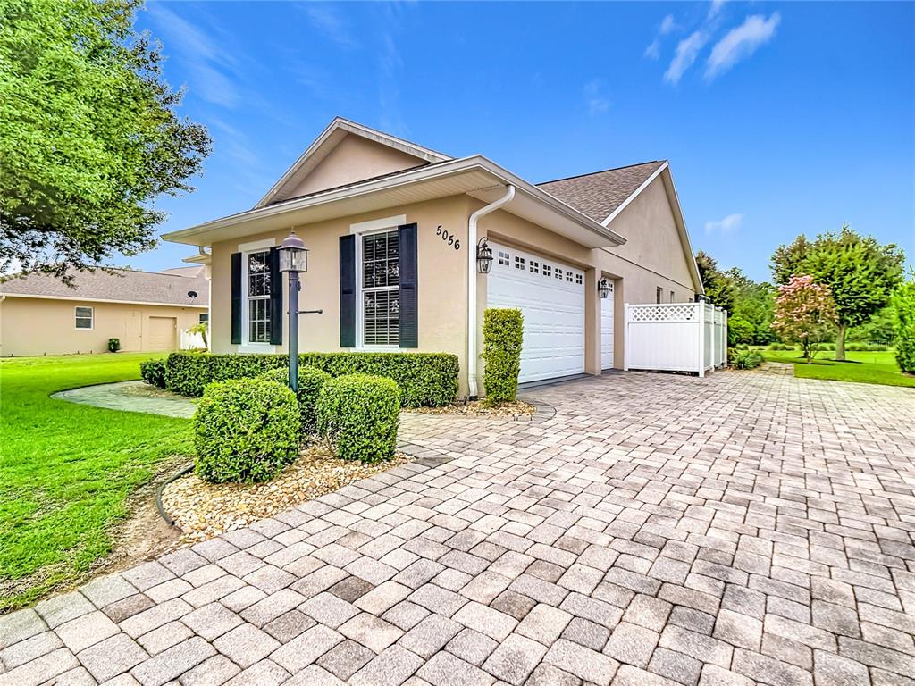A single-story house with a paved driveway, a two-car garage, and manicured landscaping — 5056 MYRTLE BEACH DRIVE, SEBRING, FL