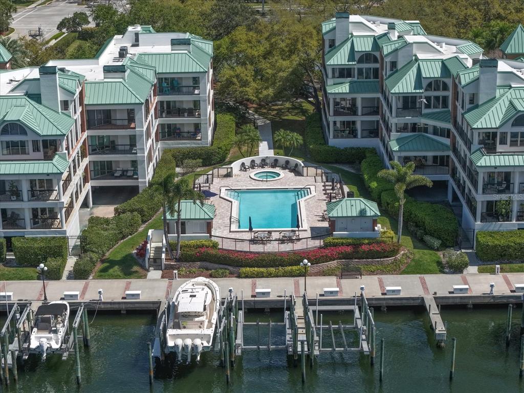 An aerial view shows a swimming pool and boat slips between two multi-story apartment buildings — 0 SEDDON COVE WAY UNIT 19, TAMPA, FL