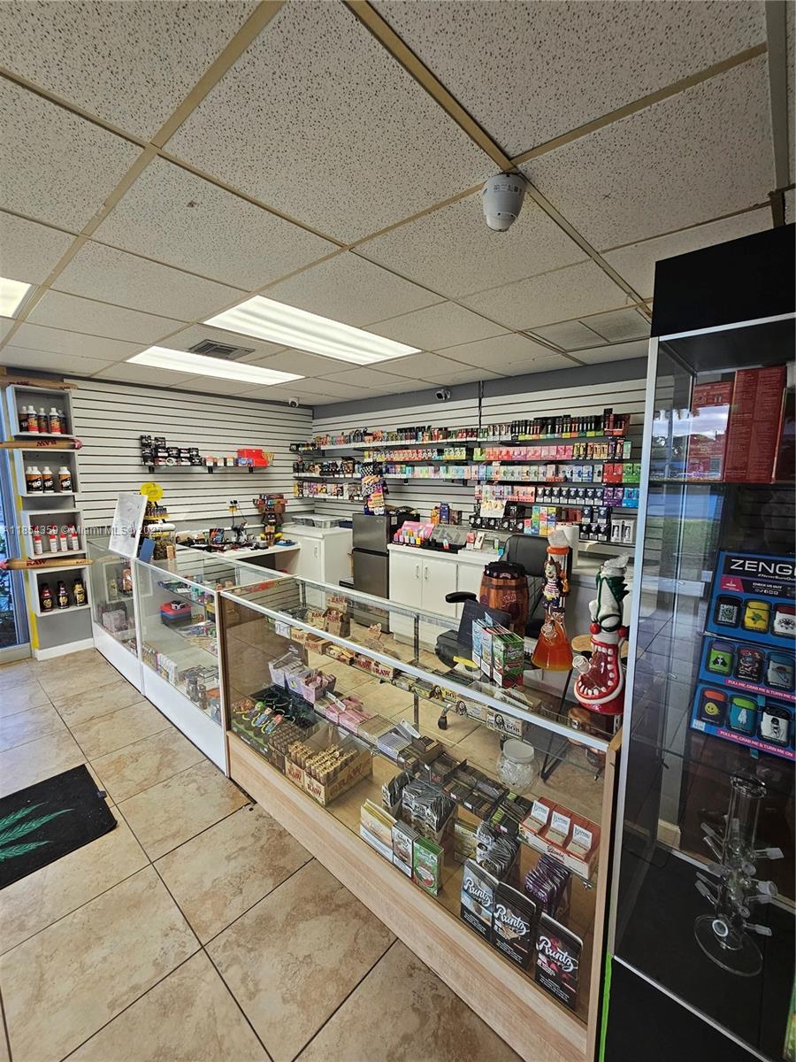 A retail smoke shop features glass display cases, wall-mounted shelving, and tiled flooring — 510 s state RD 7, Plantation FL 33317, PLANTATION, FL