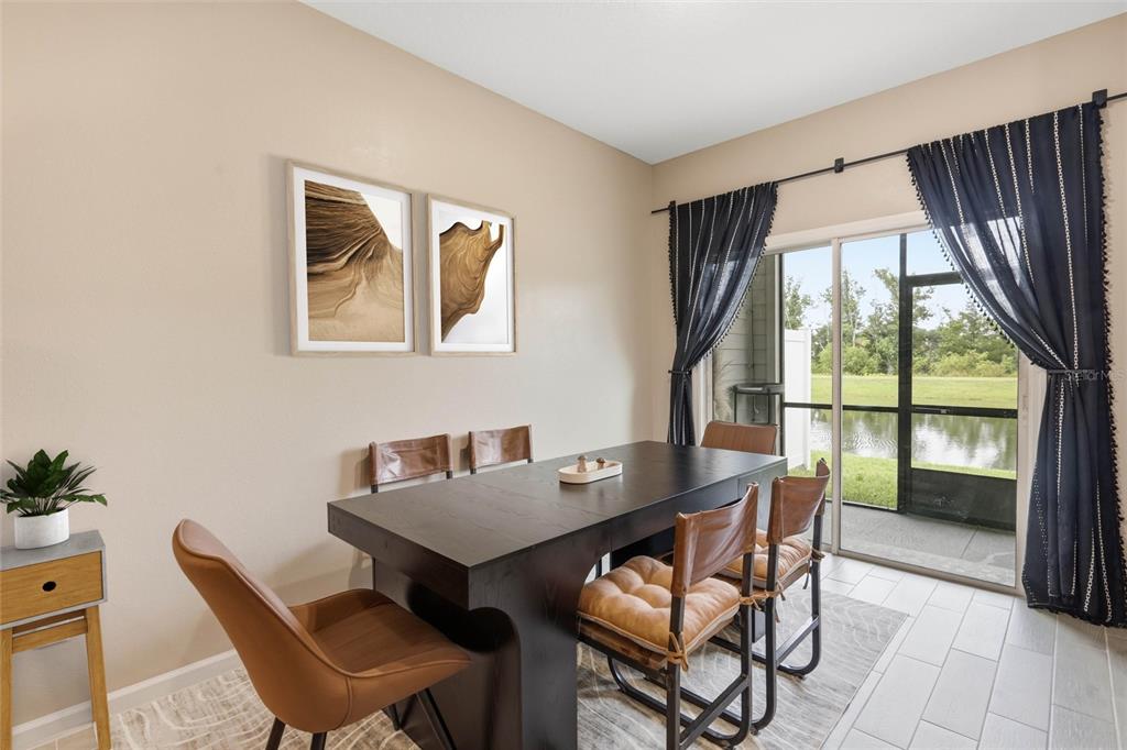 A dining room features a dark wood table, leather chairs, wall art, and sliding glass doors — 6893 GABLE GROVE AVENUE, JACKSONVILLE, FL