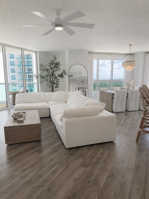 A bright living and dining area features a white sectional, wood coffee table, and floor-to-ceiling windows — 241 RIVERSIDE DRIVE UNIT 2009, HOLLY HILL, FL