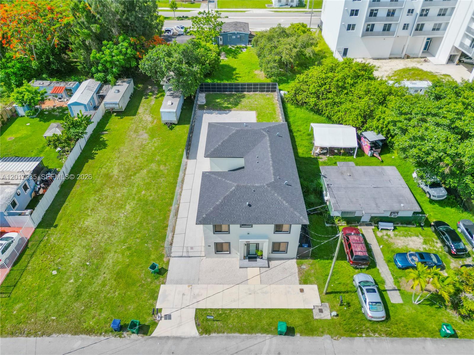 An aerial view shows a two-story house with a dark roof and a large grassy yard — 11970 SW 215th St # B, Miami FL 33177, MIAMI, FL