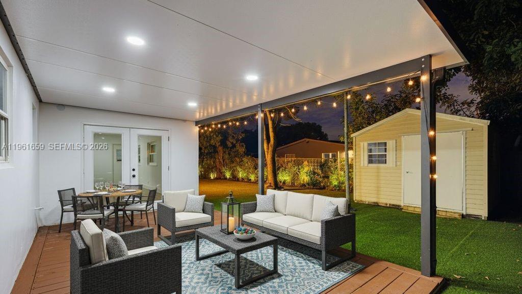 A covered outdoor patio features a wooden deck, patio furniture, and a small storage shed — 256 NW 78th Terrace, Margate FL 33063, MARGATE, FL