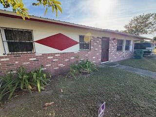 A single-story house with a brick facade, a red diamond accent, and a front door — 1063 Louisiana Avenue, Clewiston FL 33440, CLEWISTON, FL