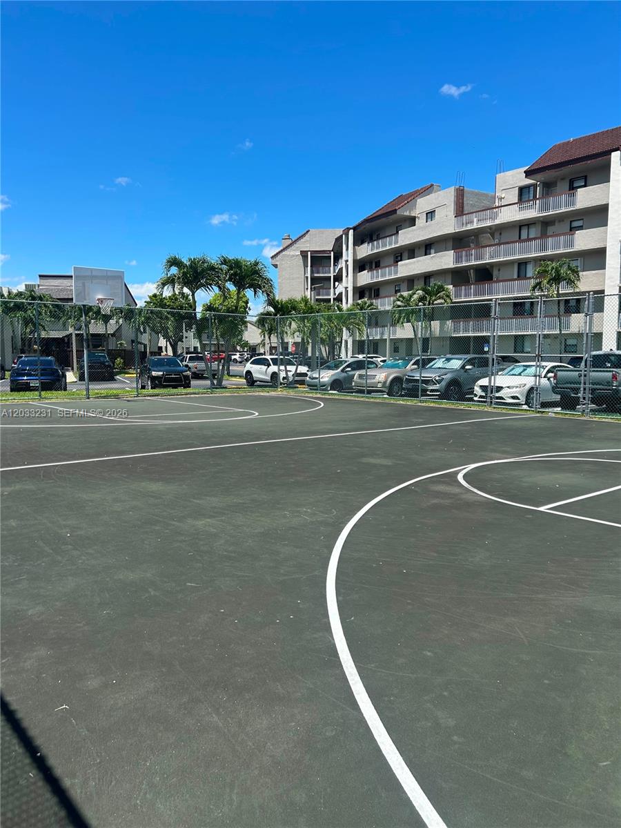 An outdoor basketball court is situated in front of a multi-story residential apartment building — 10284 NW 9th St Cir # 204, Miami FL 33172, MIAMI, FL