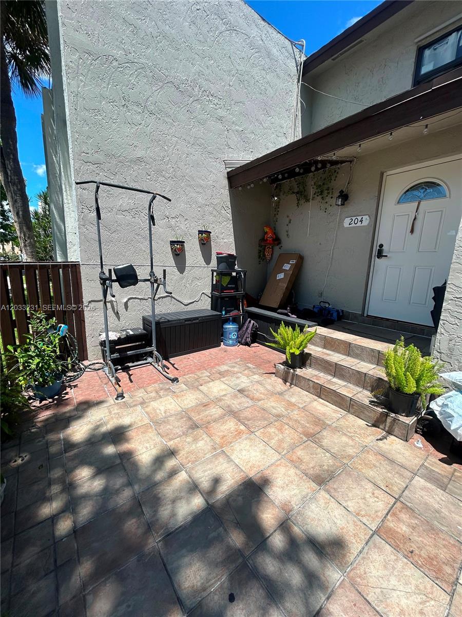 A tiled patio area leads to the front entrance of a residential unit — 10284 NW 9th St Cir # 204, Miami FL 33172, MIAMI, FL