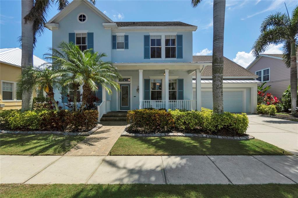 A two-story light blue house with a front porch, palm trees, and a paved walkway — 5727 SEA TROUT PLACE, APOLLO BEACH, FL