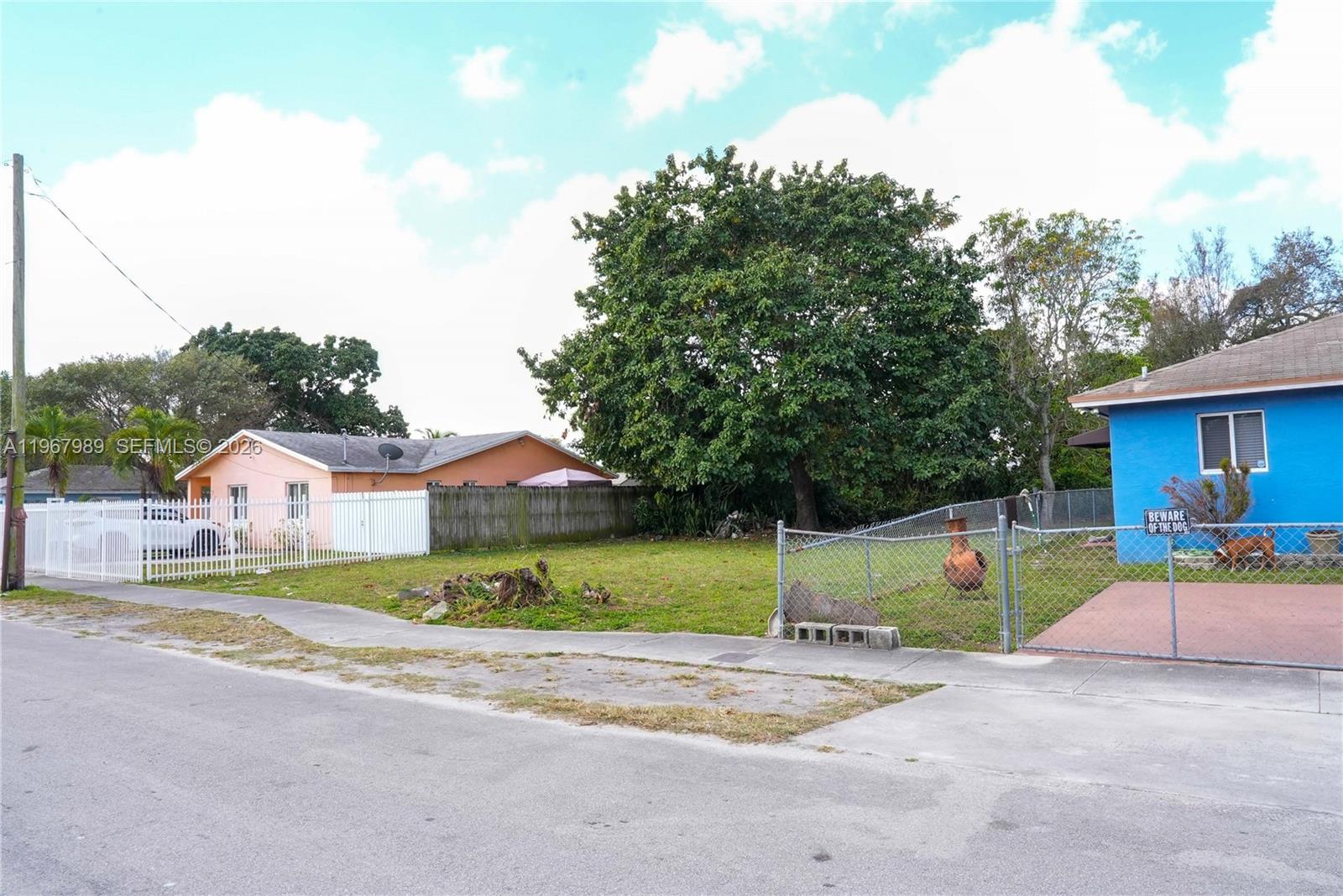 A vacant grassy lot sits between a pink house and a blue house — 7610 NW 15th Ave, Miami FL 33147, MIAMI, FL