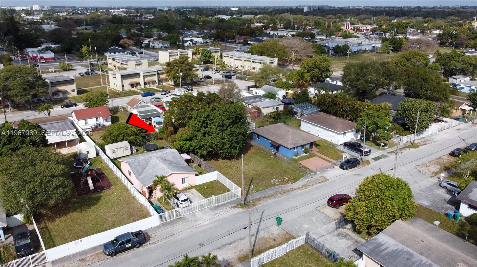 An aerial view shows a pink house with a white fence and a large backyard — 7610 NW 15th Ave, Miami FL 33147, MIAMI, FL