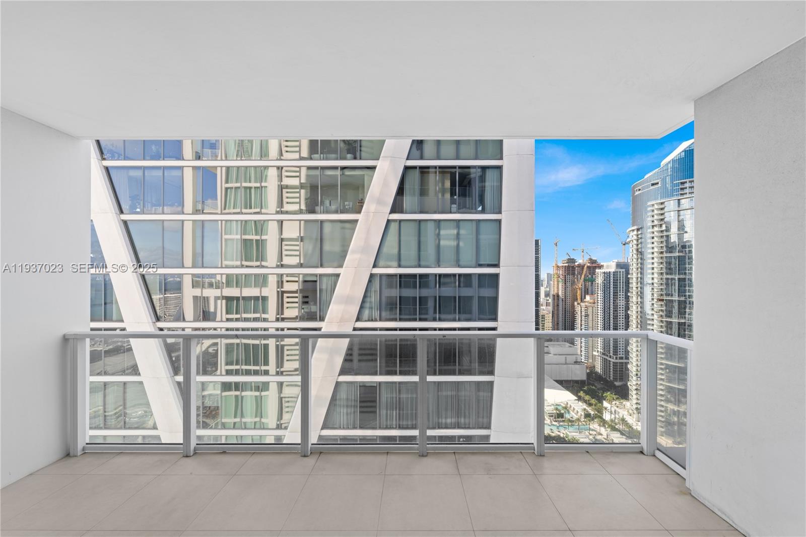 A balcony with a glass railing overlooks a dense urban skyline of modern skyscrapers — 1040 Biscayne Blvd # 4108, Miami FL 33132, MIAMI, FL