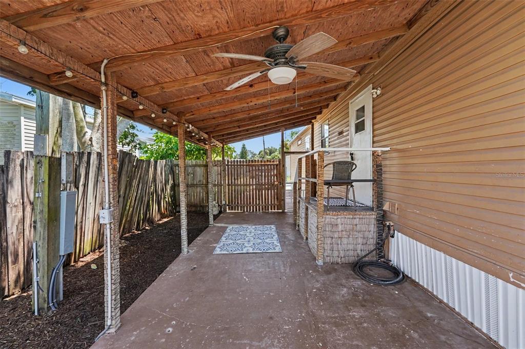 A covered outdoor patio features a concrete floor, wooden ceiling, ceiling fan, and fenced yard — 739 DRIFTWOOD LANE, TARPON SPRINGS, FL