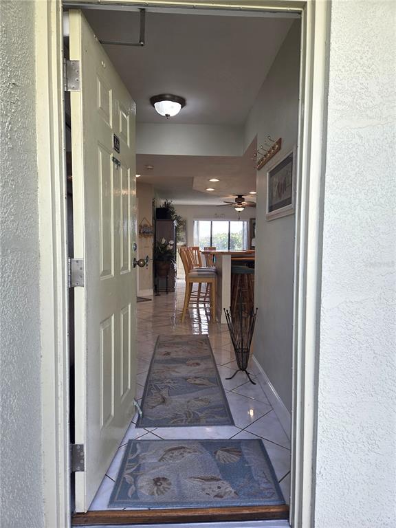 A view through an open doorway into a tiled entryway leading toward a kitchen area — 1515 PINELLAS BAYWAY S UNIT A6, TIERRA VERDE, FL