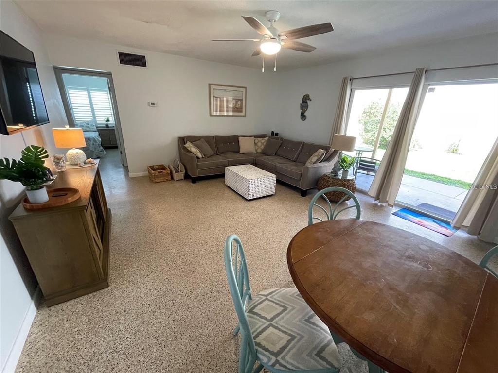 A living room features a sectional sofa, a dining table, and sliding glass patio doors — 573 N ATLANTIC AVENUE UNIT 5, NEW SMYRNA BEACH, FL