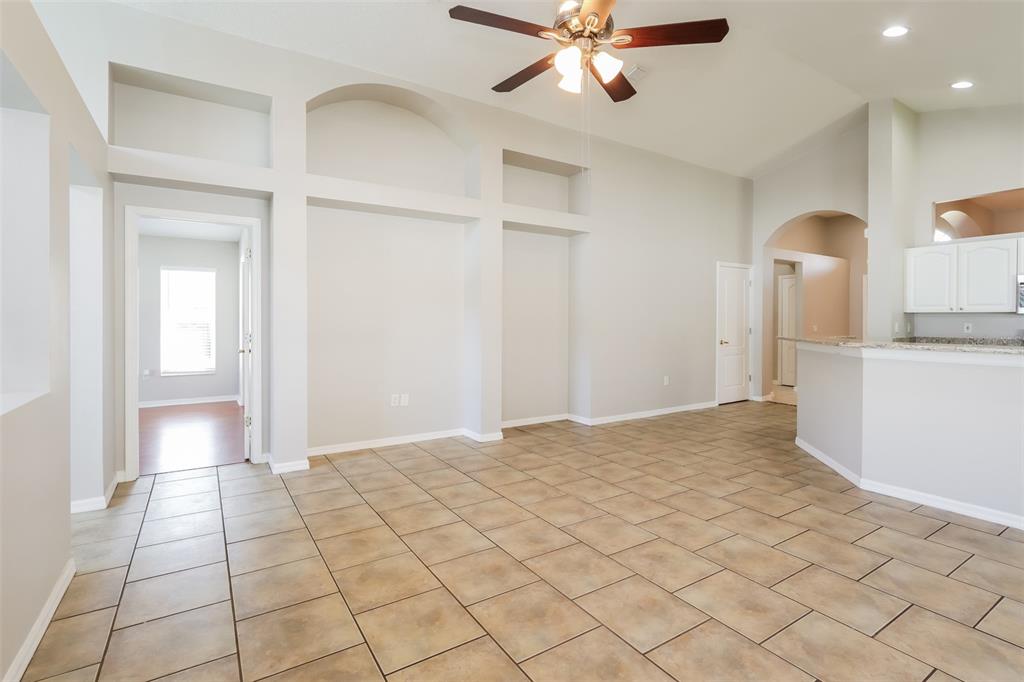 An open living area features tile flooring, arched wall niches, and a ceiling fan — 23211 BAYOU GROVE STREET, LAND O LAKES, FL