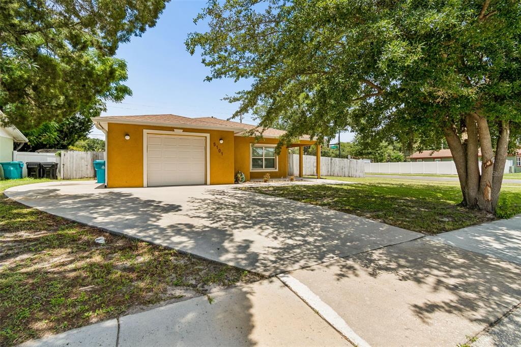 A yellow single-story house with a one-car garage and a concrete driveway — 5101 LANETTE STREET, ORLANDO, FL