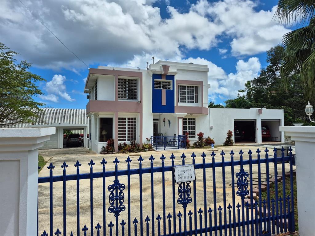 A two-story house with a blue accent wall and a blue metal fence in front — Carr. 414, Km. 3.5 BO. CRUCES, RINCON, PR