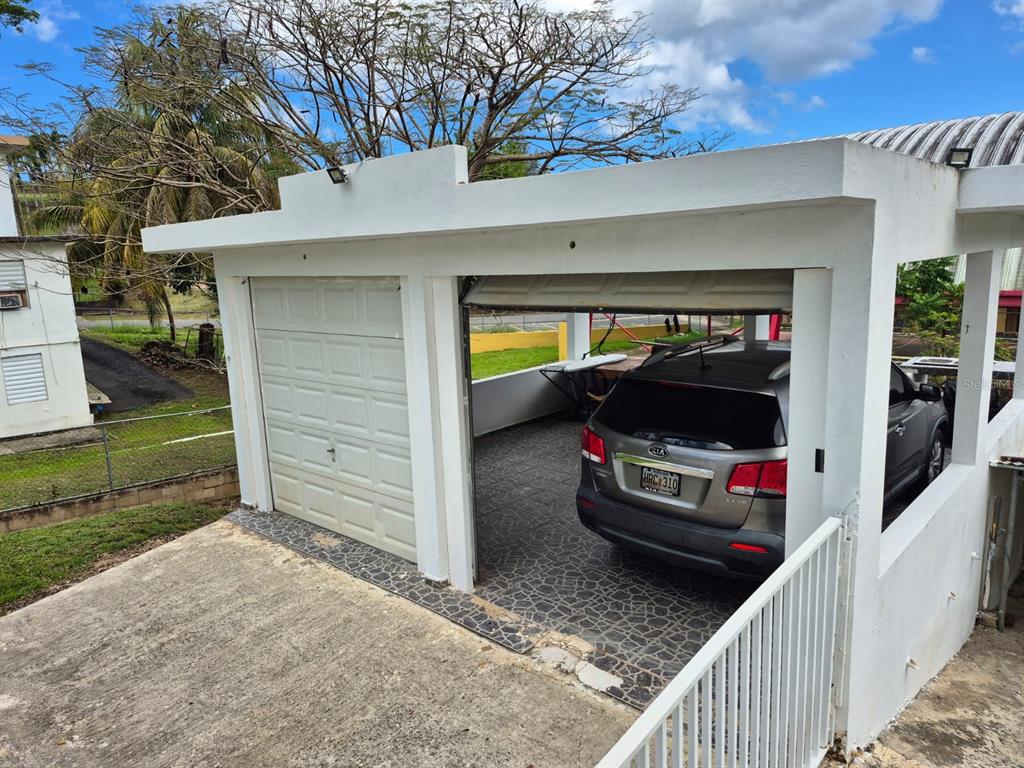 A concrete carport with one enclosed garage bay and one open parking space — Carr. 414, Km. 3.5 BO. CRUCES, RINCON, PR