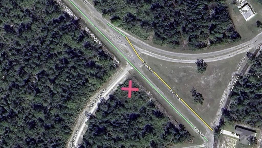 This aerial map shows a vacant lot marked with a red cross at a road intersection — CORAL GABLES DRIVE, INDIAN LAKE ESTATES, FL