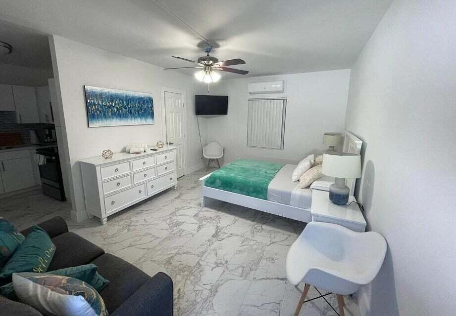 A bedroom with marble-look tile flooring, a white dresser, a bed, and a ceiling fan — 201 S Ocean Boulevard # 7, Boca Raton FL 33432, BOCA RATON, FL