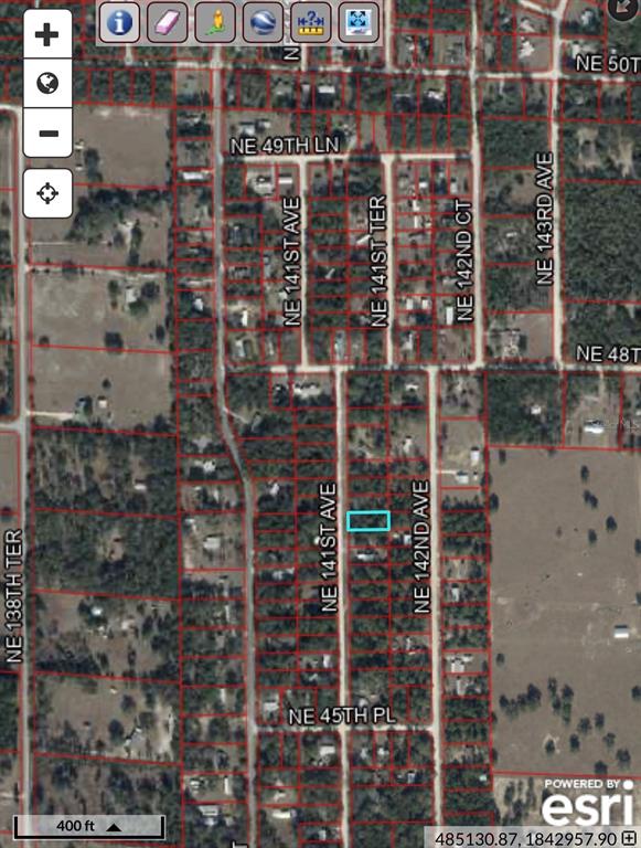 This is a satellite map showing a rectangular property parcel highlighted in blue — TBD NE 141 AVENUE, WILLISTON, FL