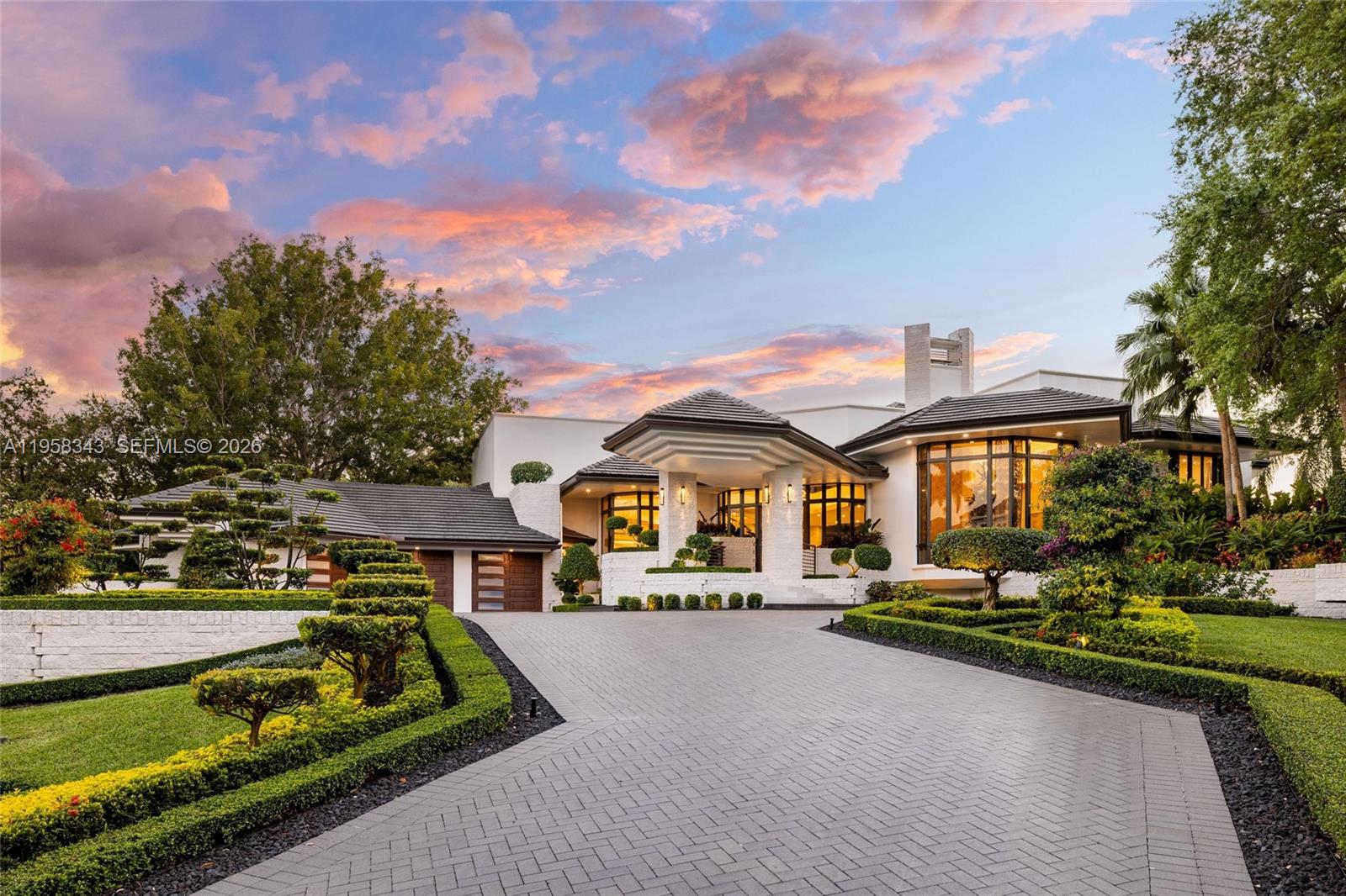 A modern house with a paved driveway, manicured landscaping, and a large covered entryway — 2965 Surrey Ln, Weston FL 33331, WESTON, FL