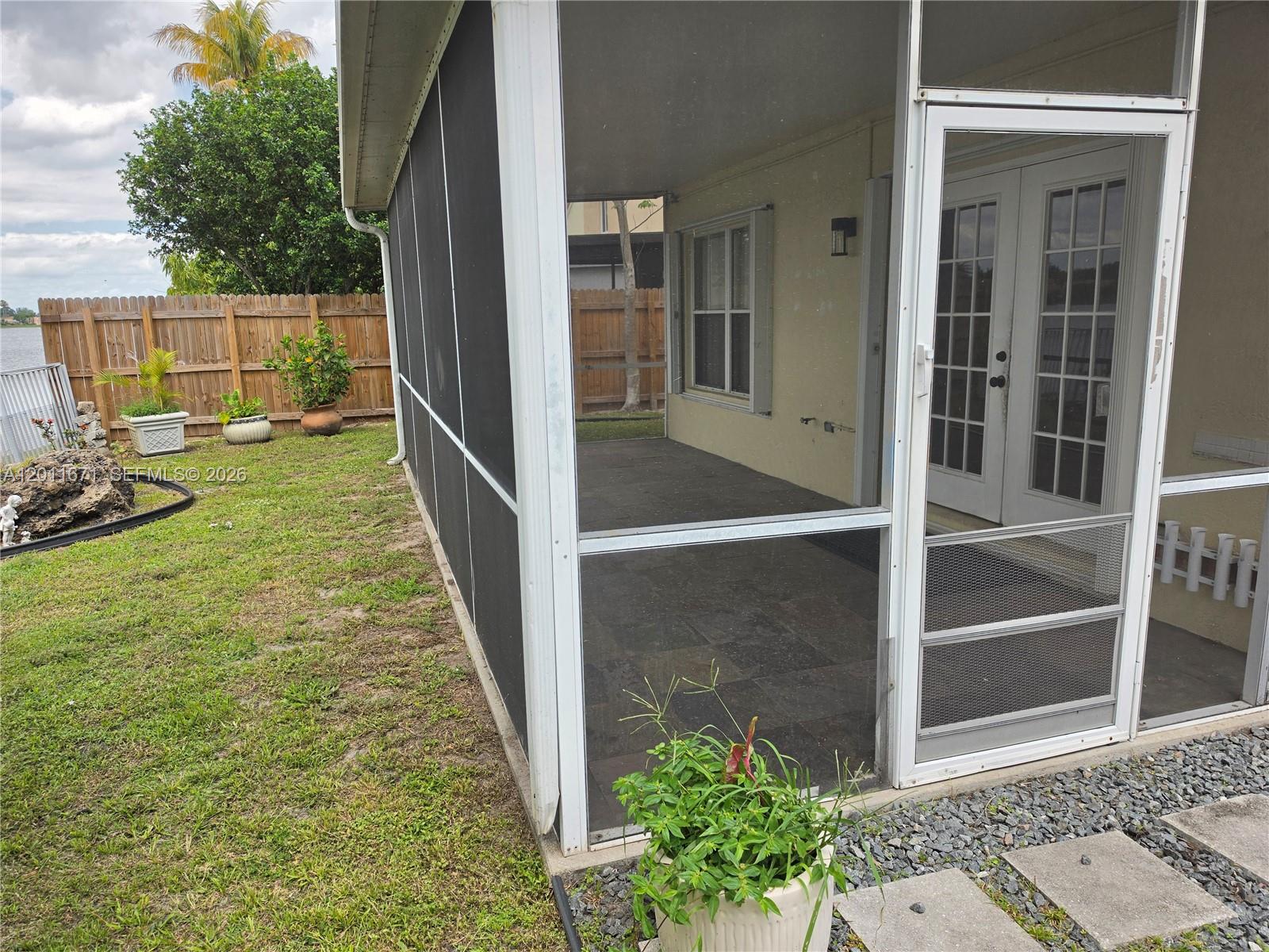 A screened-in patio features dark tile flooring and a white door leading to the house — 6178 Buena Vista Dr # 6178, Margate FL 33063, MARGATE, FL