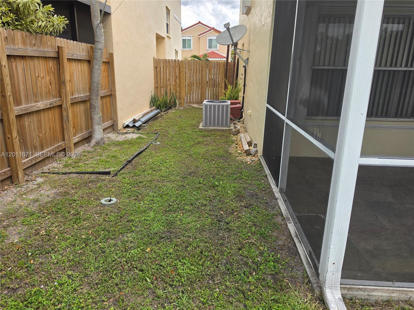 A narrow side yard features a patch of grass, a wooden fence, and an AC unit — 6178 Buena Vista Dr # 6178, Margate FL 33063, MARGATE, FL