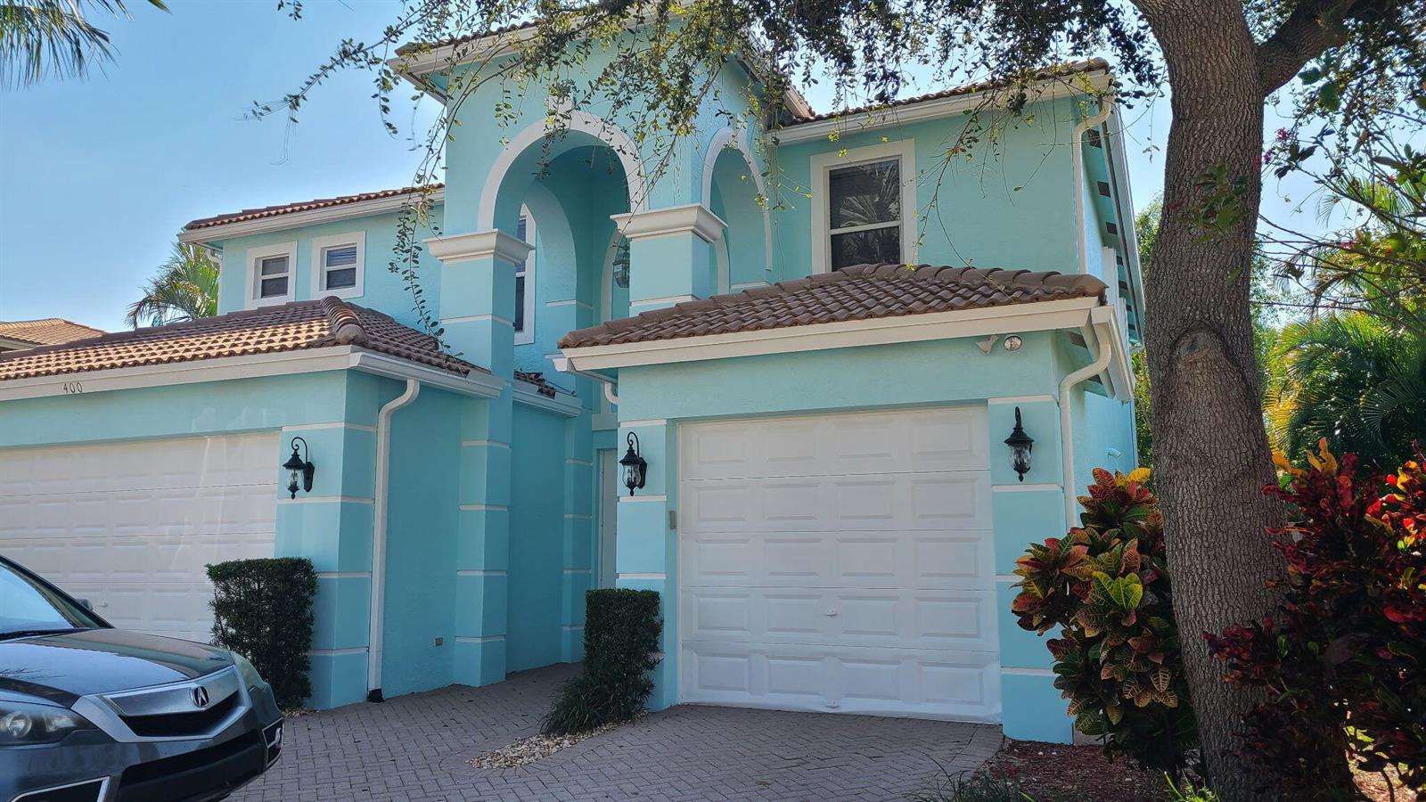 A two-story, light blue house with a tile roof and two white garage doors — 400 SW 15th Drive, Boca Raton FL 33432, BOCA RATON, FL