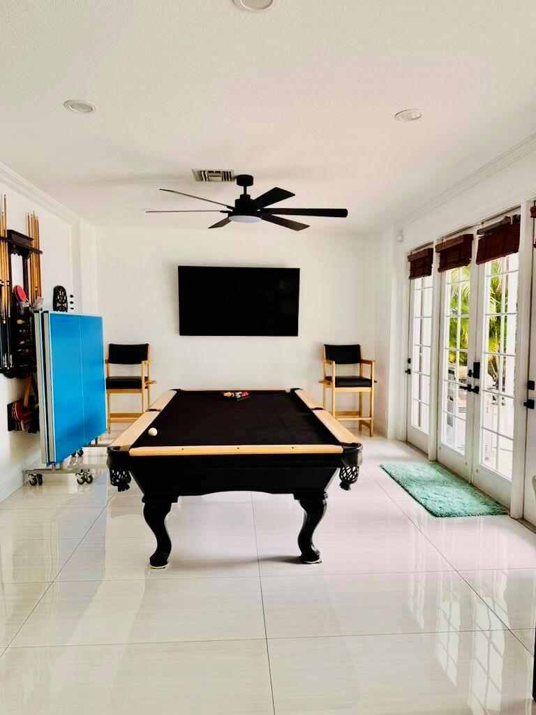 A game room features a pool table, a folded ping pong table, and tile flooring — 400 SW 15th Drive, Boca Raton FL 33432, BOCA RATON, FL