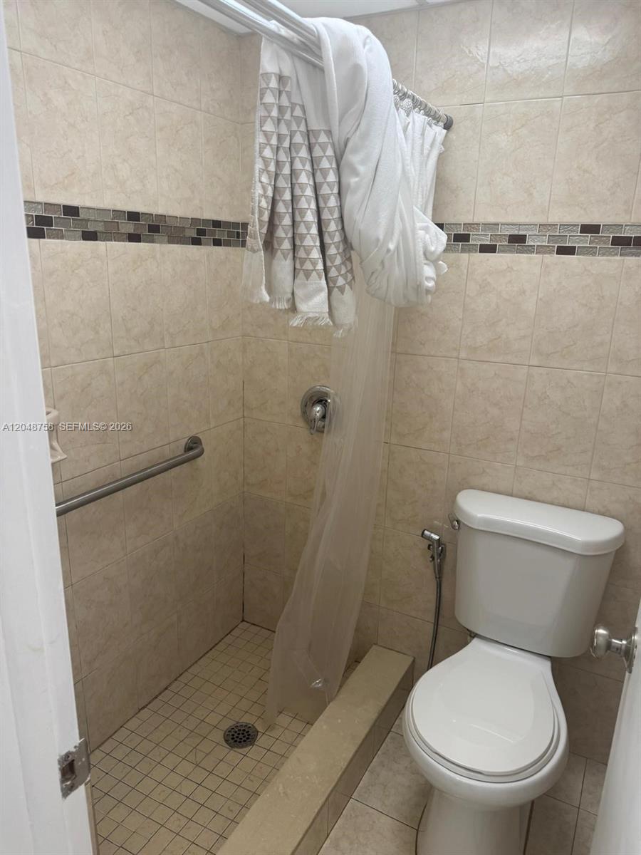 A small bathroom features a tiled walk-in shower with a grab bar and a toilet — 6901 SW 129th Ave # 4, Miami FL 33183, MIAMI, FL