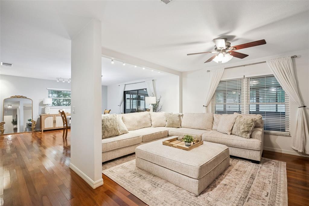 A living room features a large sectional sofa, an ottoman, and hardwood floors — 636 SWALLOW DRIVE, CASSELBERRY, FL