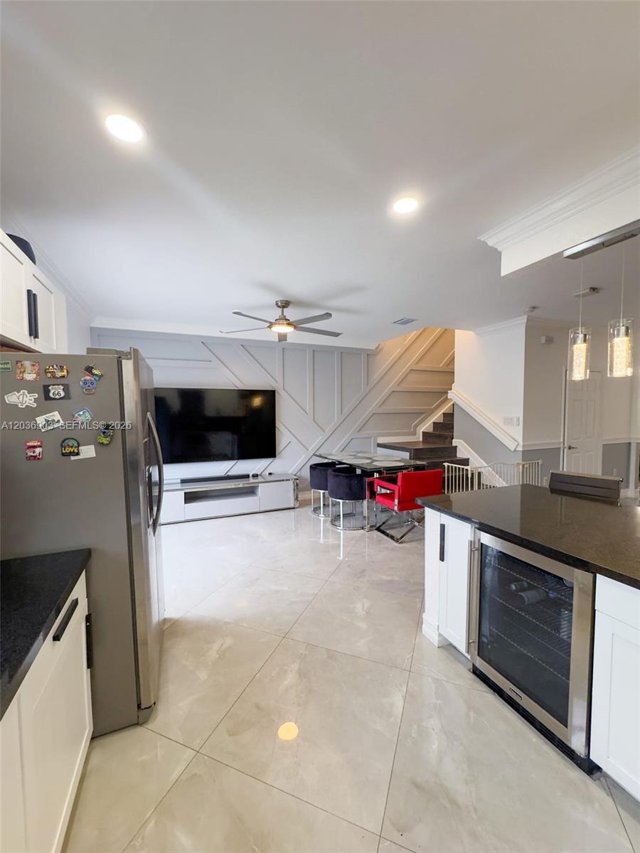 A modern kitchen and living area with tile floors, a feature wall, and stairs — 4715 Caspian Way, Davie FL 33314, DAVIE, FL