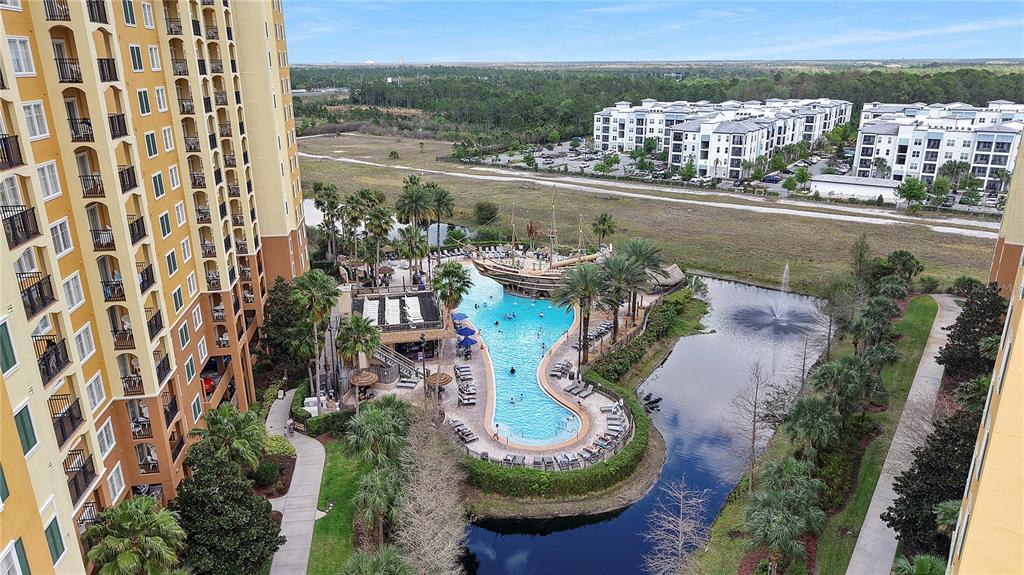 An aerial view shows a swimming pool with a pirate ship feature beside a large building — 8112 POINCIANA BOULEVARD UNIT 1306, ORLANDO, FL