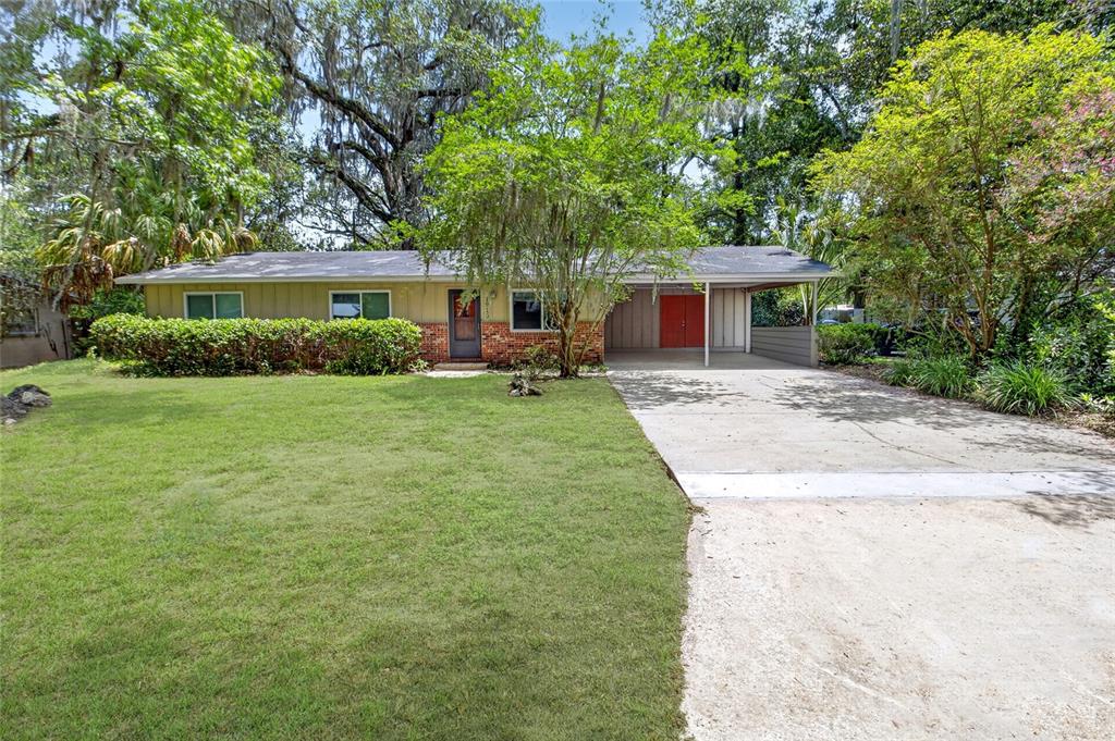 A single-story house with a brick and siding exterior features a carport and front lawn — 1915 NW 42ND PLACE, GAINESVILLE, FL