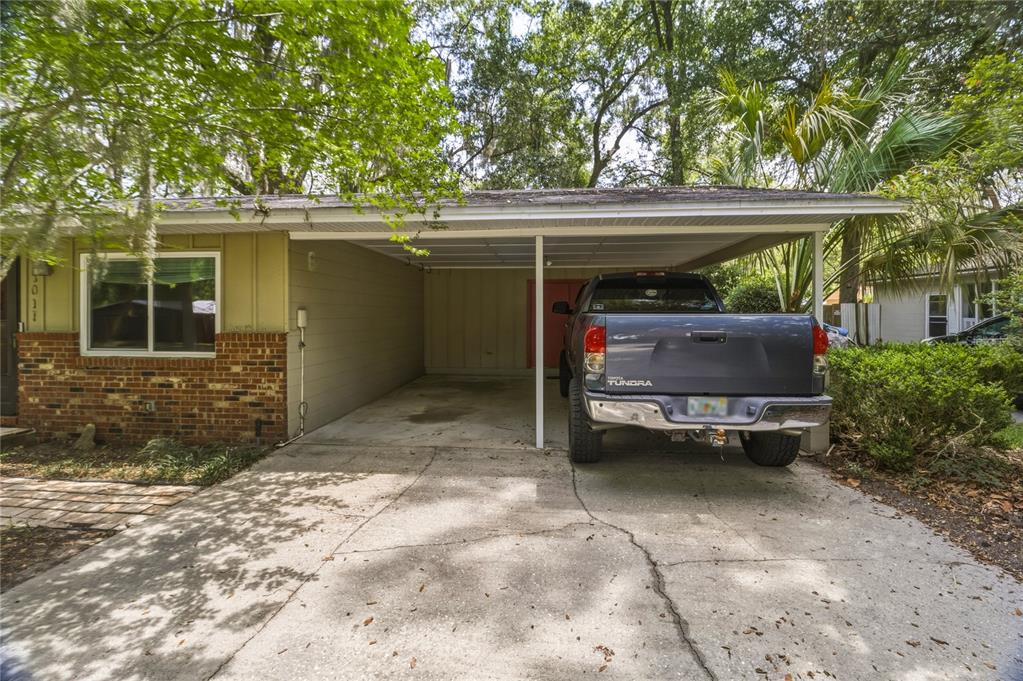 A gray pickup truck is parked under a carport attached to a house — 1915 NW 42ND PLACE, GAINESVILLE, FL