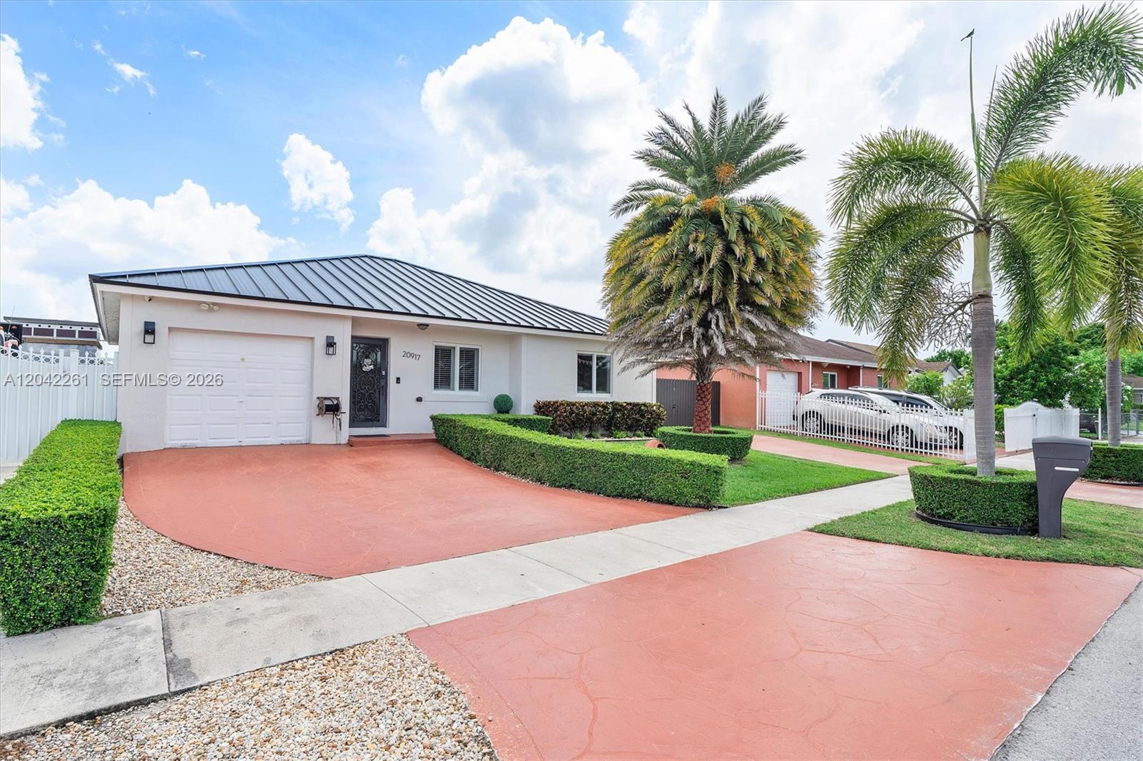 A single-story house with a metal roof, white stucco walls, and a red driveway — 20917 SW 125th Ave Rd, Miami FL 33177, MIAMI, FL