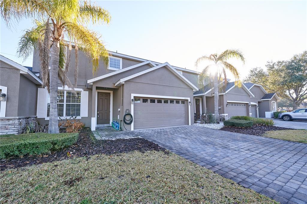 A two-story townhouse with a paved driveway, a two-car garage, and palm trees — 23903 SARDINIA DRIVE, SORRENTO, FL